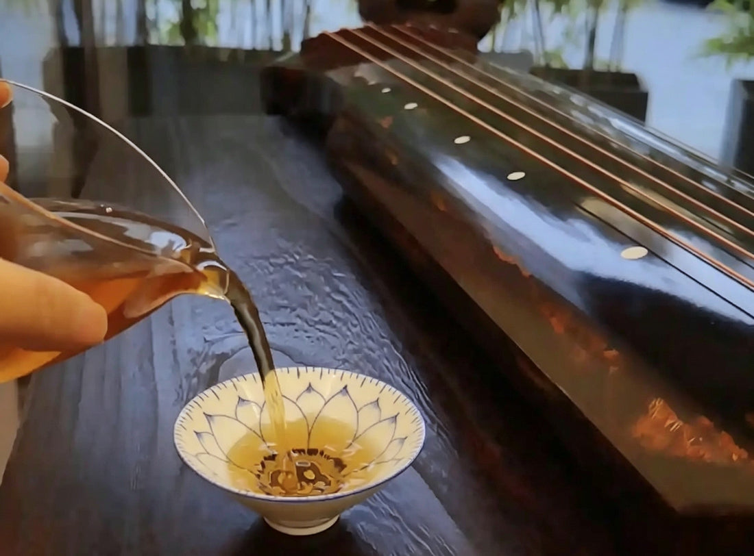"Tea poured into a lotus cup beside a guqin — qin cha yi wei, the guqin and tea share one flavor"