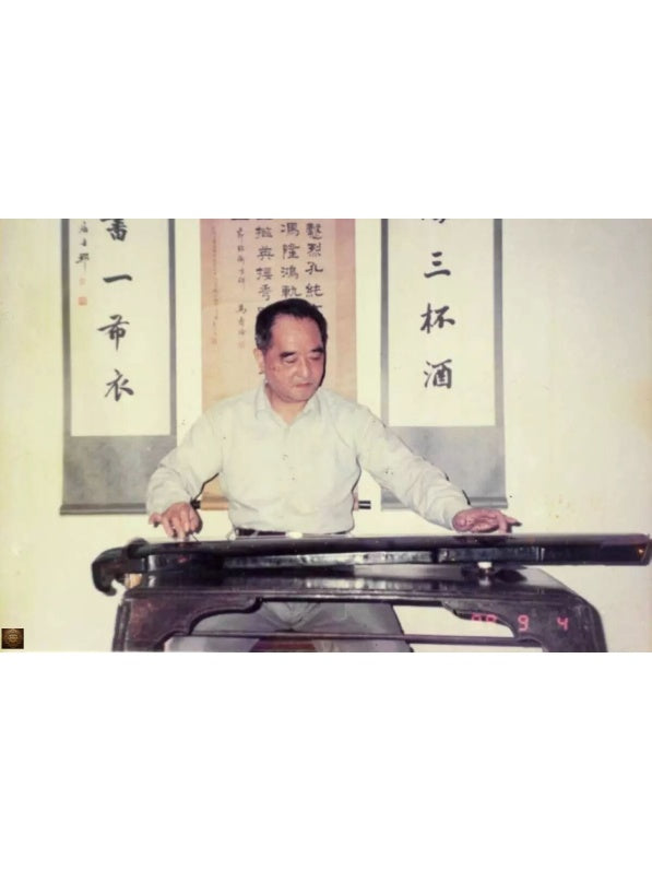 Master Mei Yueqiang playing guqin, with Chinese calligraphy scrolls in the background