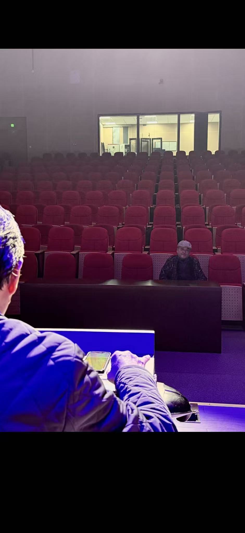 Mei Shijun listening to a student perform guqin in an empty theater. The guqin does not need an audience. It needs one person who is truly present.