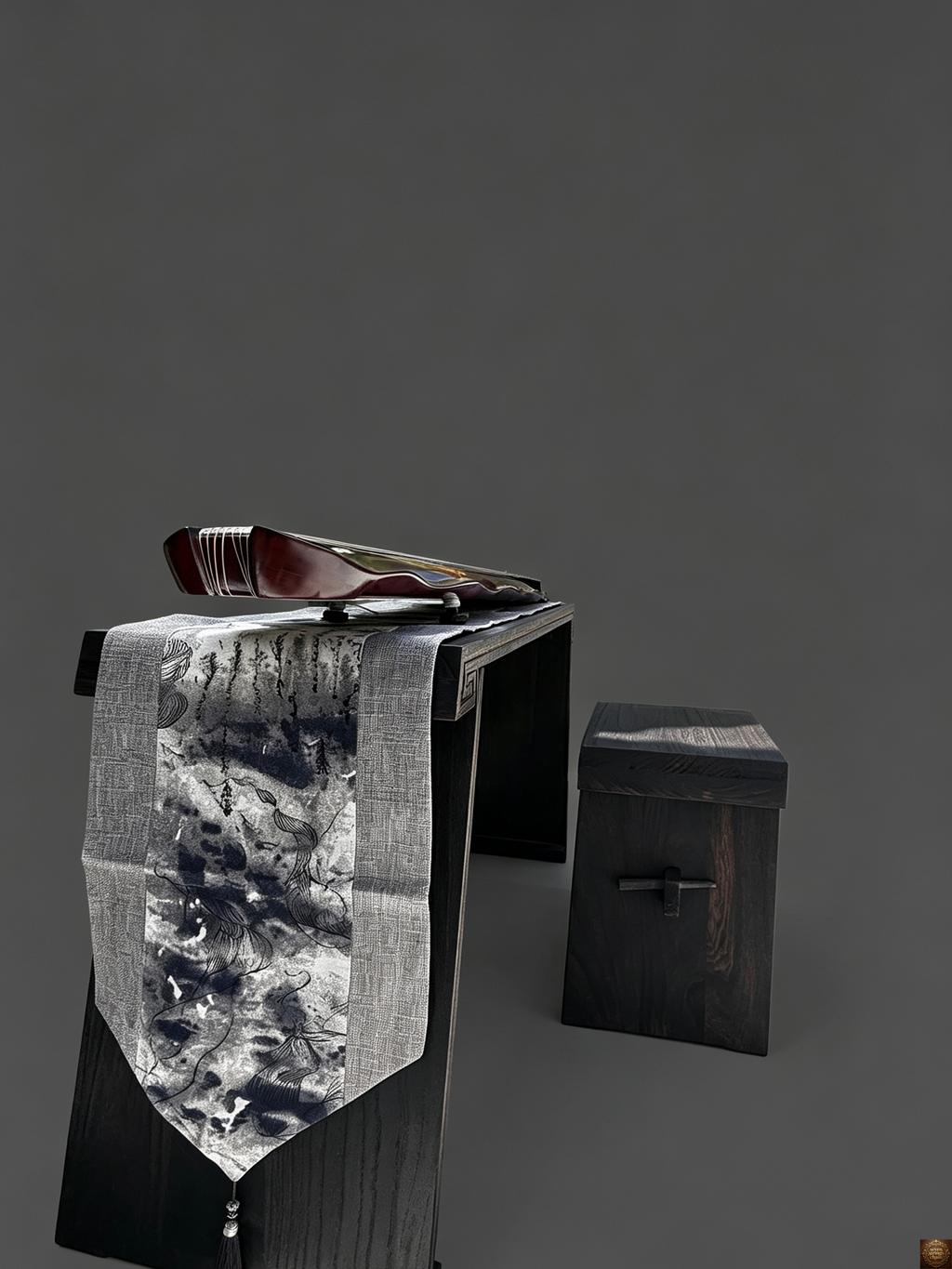 Detachable guqin table – close-up of guqin tail end showing seven tuning pegs and green silk tassels draped over grey linen table runner